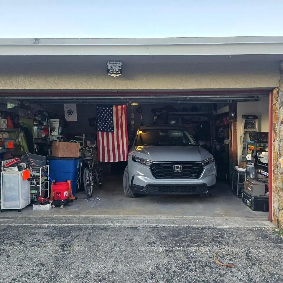 Completed residential garage door: a sectional door raised on its tracks above a paved driveway